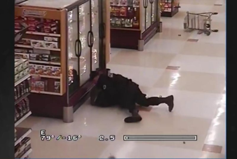 Police tackle a suspect in a Portland, Ore., Fred Meyer store after he was tripped up by a heroic "Anonymous Shopping Cart Guy." Screenshot: Portland Police Bureau/Facebook video screenshot