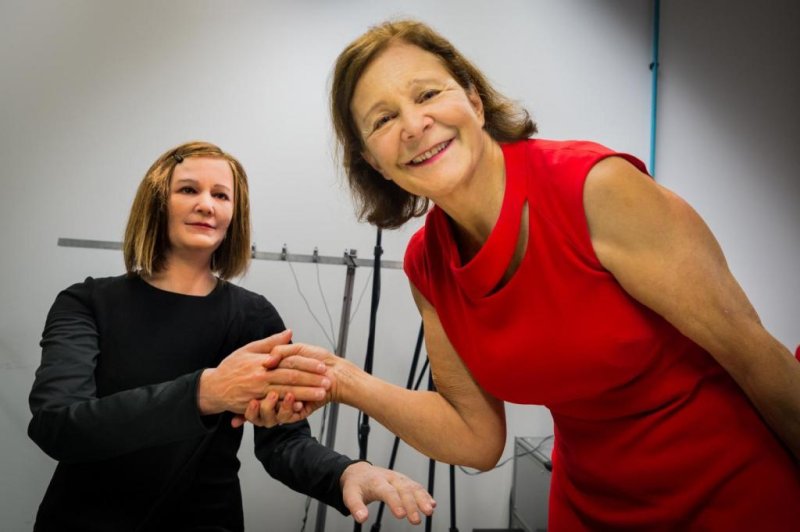 Nadia Thalmann shakes hands with Nadine, a humanoid robot with social intelligence. Photo by NTU Singapore