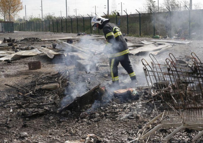 A fire official walks through the wreckage of the Grande-Synthe migrant camp in northern France. A fire on Monday destroyed about 300 huts in which about 1500 people lived. Photo by Thibault Vandermersch/EPA