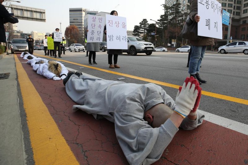 A group of Buddhists and activists seeking to improve human rights protections for illegal migrant workers engages in a bowing ceremony, a Buddhist practice in which participants stretch their entire body out on the ground, in front of Jogye Temple in Seoul on Nov. 19, 2018, in protest over the death of an illegal migrant worker from Myanmar. Photo by Yonhap
