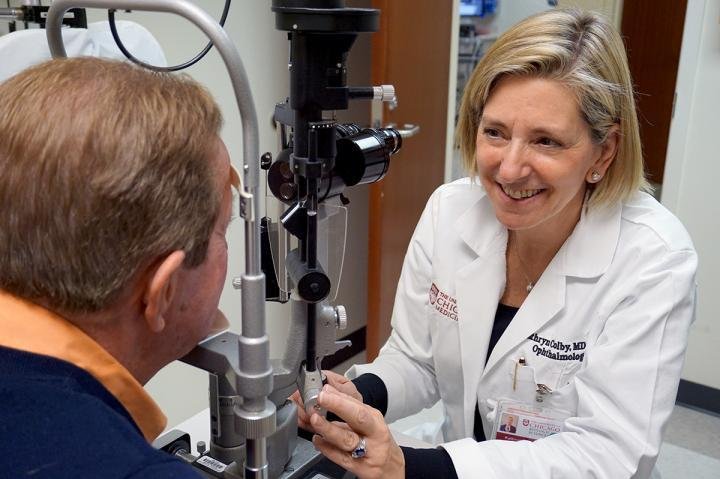 Dr. Kathryn Colby, chair of ophthalmology at the University of Chicago, checks the vision of the first patient to undergo Descemet stripping, 69-year-old Eric Thorp, during his two-year follow-up visit. Thorp reported his vision returned gradually over the course of a few weeks after surgery, like "the fog lifting out of London." Photo by Kevin Jiang/University of Chicago Medicine