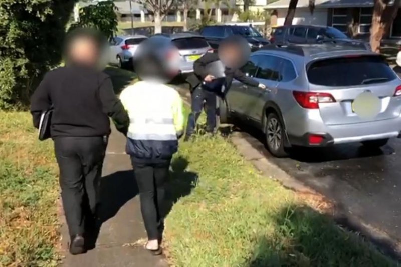 Australian Federal Police arrest a suspect as part of Operation Molto, which they said apprehended at least 44 suspected child abusers and found a number of child victims who were placed into safety. Photo courtesy Australian Federal Police/Facebook
