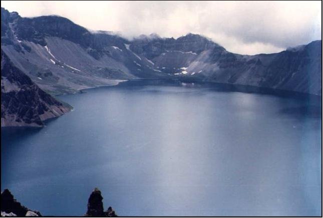 Lake Tianchi occupies the 3-mile-wide summit caldera of massive Changbaishan stratovolcano, which straddles the China/Korea border. Credit: Xiang Liu, 1983 (Changchun University)/Smithsonian Institution