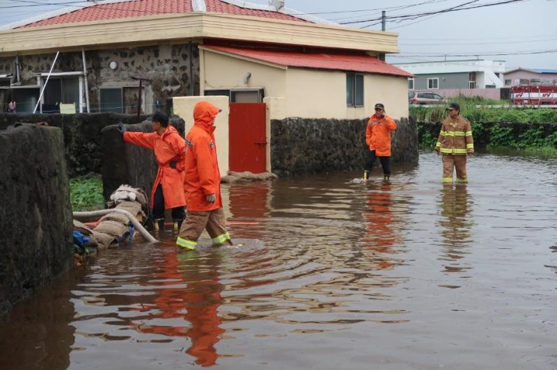 Fire authorities work on drainage as torrential rains flood a residential area in Seogwipo, a city on the southernmost island of Jeju. Weather authorities have issued a downpour warning for most of the island, except for some parts in the west. Photo by Yonhap