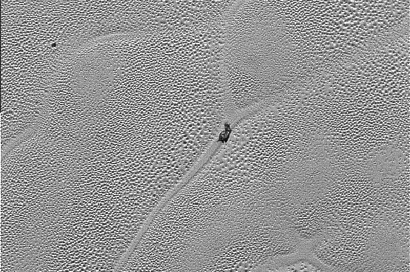 A new photo from the New Horizons mission shows a slug-like rock amid Pluto's icy plain. Photo by NASA