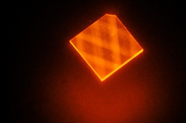 The researchers' new technique for building diamond-based magnetometers sees a angled laser beam shot into a sawed-off corner to square-like diamond chip. Photo by MIT