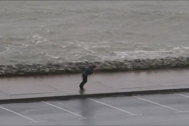 Boy walking in Ireland carried backward by the wind