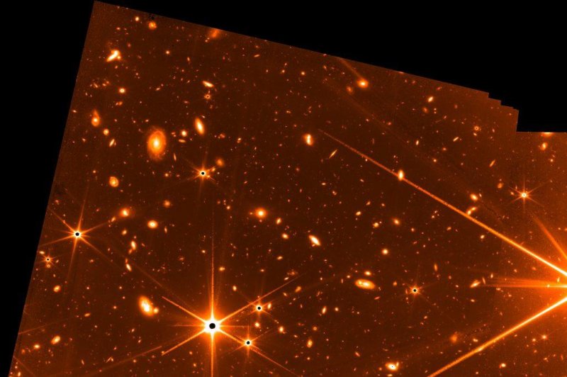 This test image was captured by NASA's James Webb Space Telescope in May. The dots with six sunbeams stretching outward are stars, while the other sources of light are distant galaxies. Image courtesy of NASA, CSA, FGS team