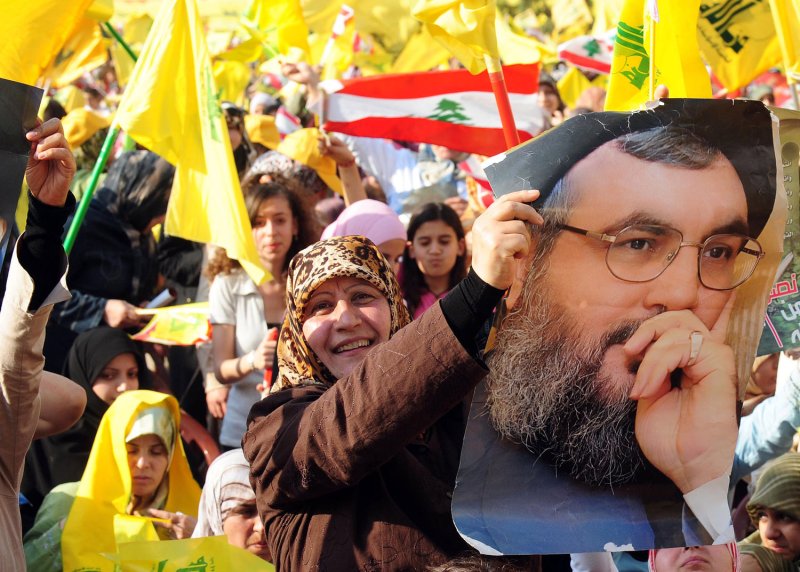 Lebanese Moslem Shiite women carry posters of Hezbollah leader Hassan Nasrallah in Beirut’s southern suburbs on May 26, 2008. to his televised speech. (UPI File Photo)