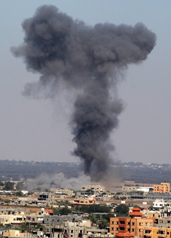 Smoke rises from buildings hit by an Israeli air strike in Rafah, Gaza Strip on July 16, 2014. The Israeli strikes continue after an Egyptian ceasefire proposal was rejected by Hamas. UPI/Ismael Mohamad