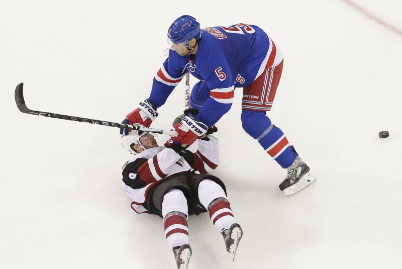 New York Rangers defenseman Dan Girardi puts his hand on the helmet of Arizona Coyotes' Tobias Rieder who falls to the ice in the 3rd period at Madison Square Garden in New York City. File photo by John Angelillo/UPI