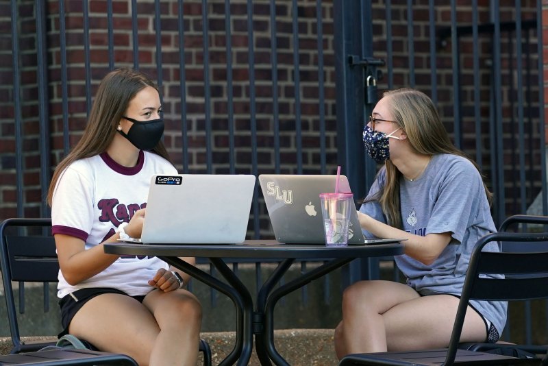 Masked students sit at a cafe on the Saint Louis University campus in St. Louis in August 2020. File Photo by Bill Greenblatt/UPI
