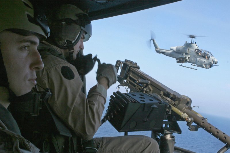 An AH-1 helicopter escorts a UH-1Y helicopter while U.S. Marine Corps Staff Sgt. Bryan E. Campbell prepares an M2.50 caliber machine gun in support of counter-piracy surveillance operations over the Gulf of Aden, April 6, 2009. Hijacked Maersk-Alabama cargo ship captain Richard Phillips was rescued by U.S. Navy forces, killing three pirates, on April 12, 2009. (UPI Photo/Robert C. Medina/U.S. Marines)