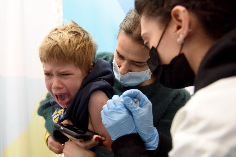 An Israeli healthcare worker administers a Pfizer-BioNTech COVID-19 vaccine to a boy in a Clalit vaccination center in Jerusalem in December 2021. File Photo by Debbie Hill/UPI