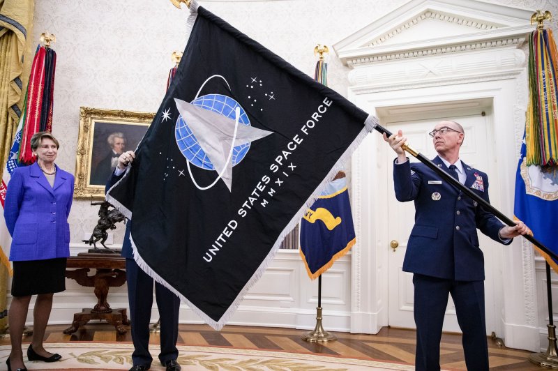 Gen. Jay Raymond (R), Chief of Space Operations, and CMSgt Roger Towberman (L), with Secretary of the Air Force Barbara Barrett present President Donald Trump with the official flag of the United States Space Force in the Oval Office at the White House in Washington, D.C. on May 15, 2020. Photo by Samuel Corum/UPI | <a href="/News_Photos/lp/1bd956edc2dd94e739edd39153bb11b3/" target="_blank">License Photo</a>