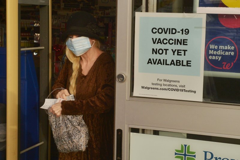 A shopper walks past a sign on the entrance to a pharmacy that reads "COVID-19 Vaccine Not Yet Available" in Burbank, Calif., on Tuesday. Photo by Jim Ruymen/UPI