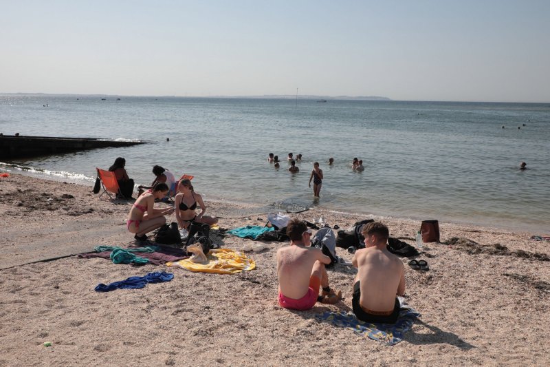 People in Whitstable, Kent, took to the beach Tuesday as Britain recorded its highest temperature in history. Photo by Hugo Philpott/UPI | <a href="/News_Photos/lp/a22704d7de1db4e3979f8216da6eaa98/" target="_blank">License Photo</a>