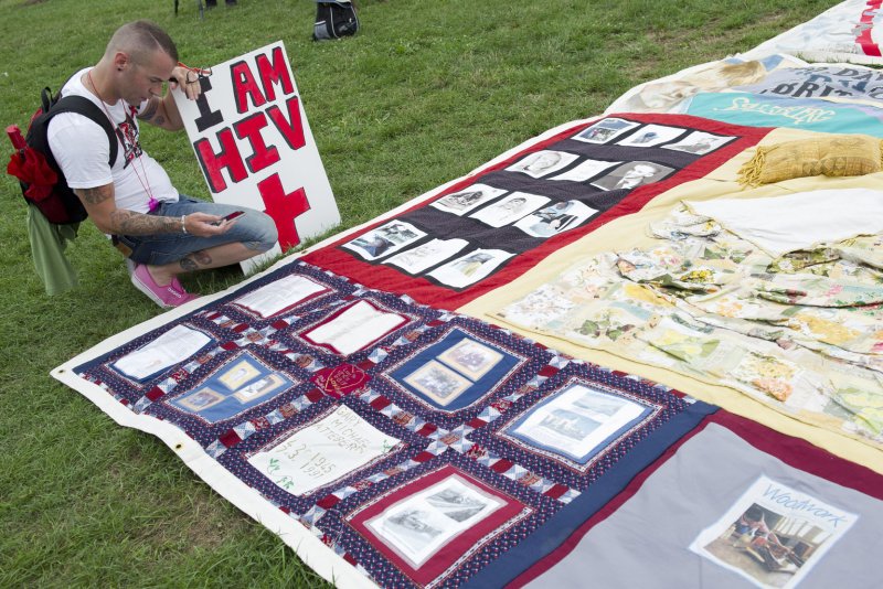A man photographs a portion of the AIDS Quilt during the Keep the Promise on HIV/AIDS rally celebrating the opening of the International AIDS Conference on the National Mall in Washington, D.C., on July 22, 2012. File Photo by Kevin Dietsch/UPI | <a href="/News_Photos/lp/29c9b05522cccdaabf93bd1c7bf030a0/" target="_blank">License Photo</a>