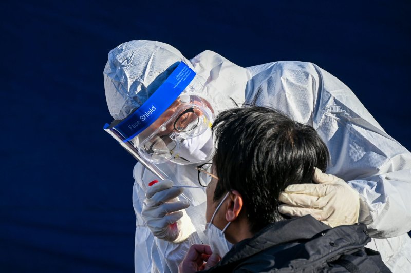 A health worker tests a patient for COVID-19 at a new temporary walk-in site in Seoul, South Korea. File Photo by Thomas Maresca/UPI