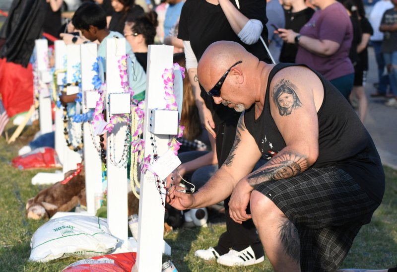 A man in Allen, Texas, pays his respects before crosses marking the eight victims of a May 6 mass shooing at a local shopping mall shooting. Photo by Ian Halperin/UPI