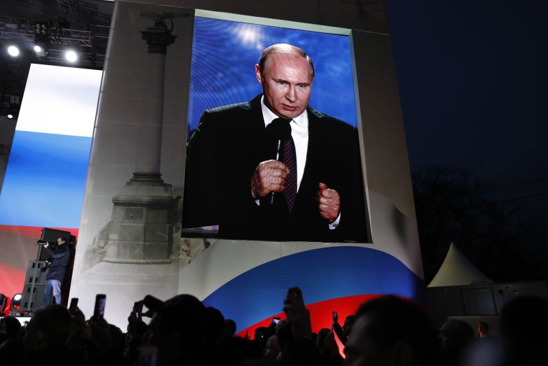Russian President Vladimir Putin is seen on giant screen as he addresses a rally on Nakhimov Square in Sevastopol, Crimea on Wednesday, his last official day of the presidential elections campaign. The vote is Sunday. Photo by Yuri Gripas/UPI