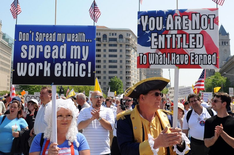 Demonstrators holds signs at a Tea Party rally at Freedom Plaza on tax day in Washington on April 15, 2010. A poll by Pew Research Center released in Jan. 2015 showed over half of America's wealthiest thought the poor had it easy due to government benefits. UPI/Roger L. Wollenberg