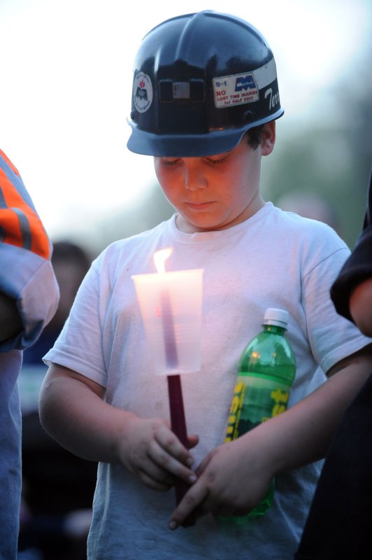 Justin Cooper, 11, wears his father's mining hard hat during a candle light vigil for the 25 coal miners who were killed in 2010. Coal miner deaths have gradually decreased since 2010, but 2017 saw a sharp spike from the year before. Photo by Roger L. Wollenberg/UPI