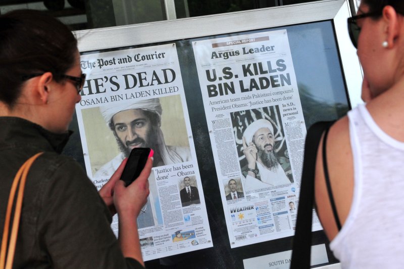 People stop to look at the front page headlines from around the country that announce the death of Al-Qaida terror leader Osama bin Laden in front of the Newseum in Washington on May 2, 2011. UPI/Kevin Dietsch