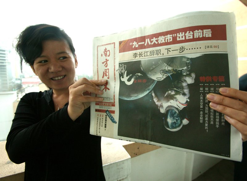 A Chinese woman shows a newspaper showing China's first space walk, in Beijing on September 28, 2008. Three Chinese astronauts returned safely to Earth on Sunday after making the country's first spacewalk, with a hero's welcome awaiting the men whose journey captivated the nation. (UPI Photo/Stephen Shaver)