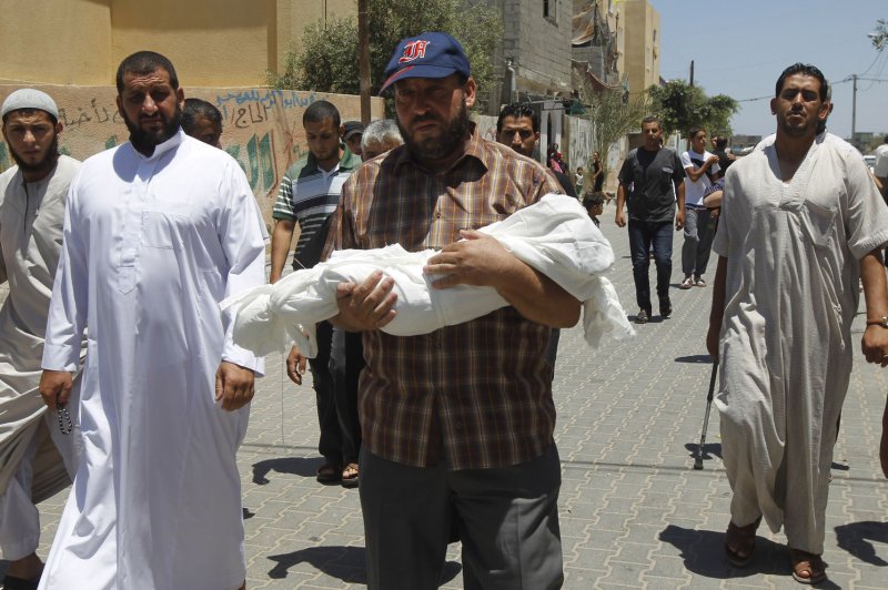 The body of five-month-old Lama Al Satari is carried by her father during her funeral in Rafah, Gaza Strip on July 16, 2014. She was killed after an Israeli air strike hit near her house in Tal Al Sultan in Rafah. The Israeli strikes continue after an Egyptian ceasefire proposal was rejected by Hamas. UPI/Ismael Mohamad