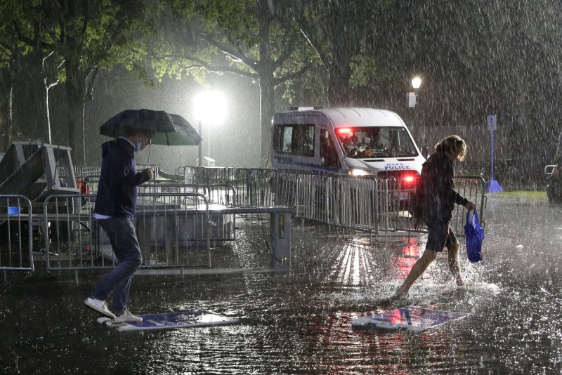 Tennis attendees use signs to step over puddles as they exit the grounds during a massive downpour of rain from Hurricane Ida at the 2021 US Open Tennis Championships on September 1 in New York City. File Photo by John Angelillo/UPI