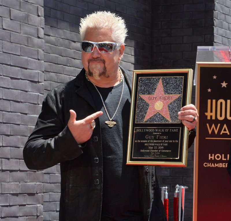 Guy Fieri holds a replica plaque during an unveiling ceremony honoring him with the 2,664th star on the Hollywood Walk of Fame in Los Angeles on Wednesday. Photo by Jim Ruymen/UPI