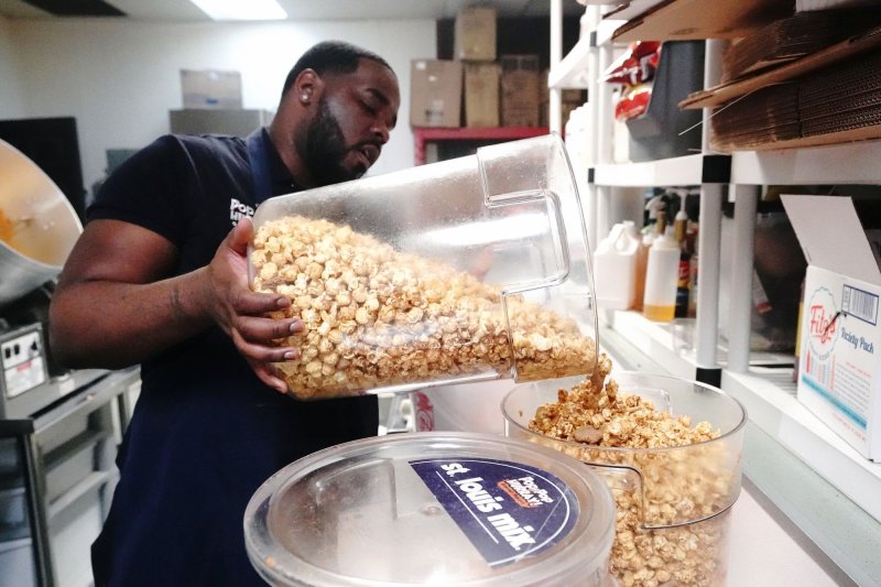 Tony Davis, owner of Pop Pop Hurray, fills a container of cheese and caramel popcorn as he begins to prepare for National Popcorn Day, at his retail location in Ferguson, Missouri on January 10, 2022. The Labor Department said employee costs rose 1% in the fourth quarter of 2022. File Photo by Bill Greenblatt/UPI