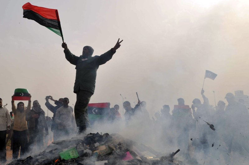 A Libyan stands atop a burning heap of books authored by Libyan leader Moammar Gadhafi at a local park of the Benghazi, Libya on March 2, 2011. Gadhafi warned the West against intervening in the rebellion against his rule. UPI/Mohamaad Hosam | <a href="/News_Photos/lp/ad8da9625fd0c06e61a131ac65f4f631/" target="_blank">License Photo</a>