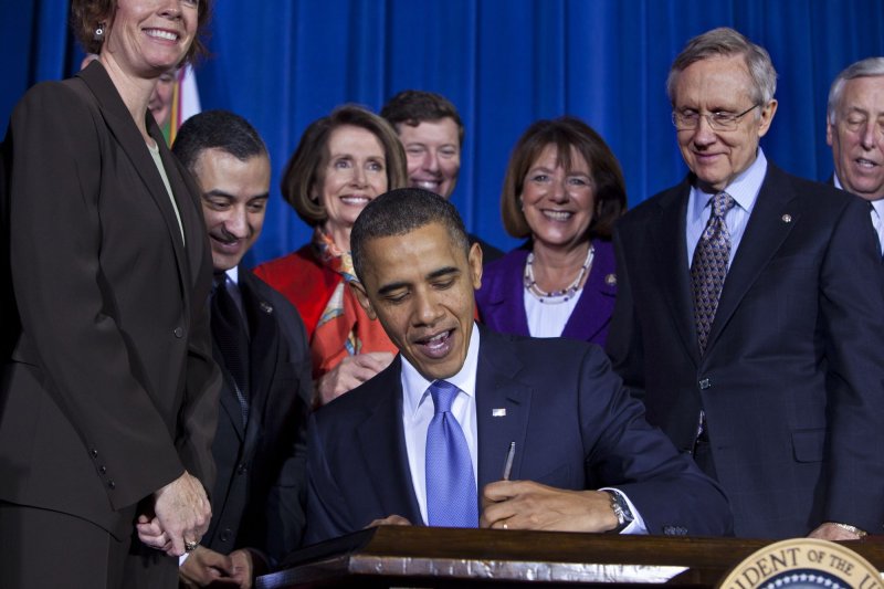 U.S. President Barack Obama, surrounded by lawmakers and bill supporters, signs into law the Don't Ask, Don't Tell Repeal Act of 2010, which will allow openly gay, lesbian, or bisexual soldiers to serve in the military, in a signing ceremony at the Department of the Interior in Washington on December 22, 2010. The repeal will take at least 60 days to go into effect, and has the backing of most of the military, including Defense Secretary Robert Gates. UPI/Jim Lo Scalzo/Pool | <a href="/News_Photos/lp/bb68c5708e68da37feee1b1030d31b18/" target="_blank">License Photo</a>