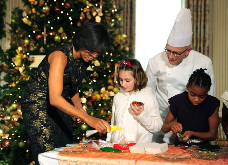 First Lady Michelle Obama decorates cookies with children of military families who helped to organize the Quantico and Anacostia branches of the Marine Corps Reserve Toys for Tots drive, at the White House in Washington on December 1, 2010. UPI/Kevin Dietsch