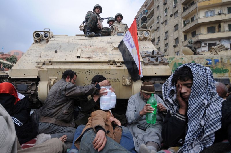 Egyptian anti-government demonstrators camp next to an army tank in Cairo's Tahrir Square on February 7, 2011 on the 14th day of protests calling for the ouster of President Hosni Mubarak. UPI