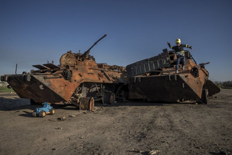 A young boy plays on a burned out Russian tank near Irpin, Ukraine on Monday. Photo by Ken Cedeno/UPI