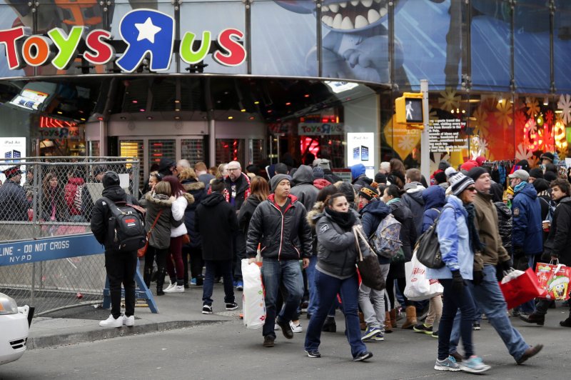 Shoppers holding bags cross the street near Toys R Us in Times Square on Black Friday in New York City on Nov. 28, 2014. For nearly a decade, Black Friday has traditionally been the official start to the busy buying binge sandwiched between Thanksgiving and Christmas. UPI/John Angelillo