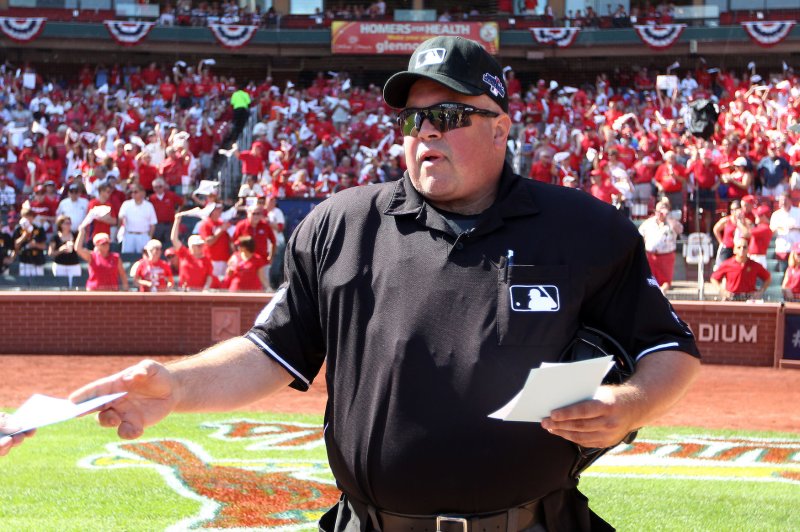 Homeplate umpire Wally Bell hands lineup cards back to the managers before Game 2 of the National League Division Series between the Pittsburgh Pirates and the St. Louis Cardinals at Busch Stadium in St. Louis on October 4, 2013. Bell died of an apparent massive heart attack in a Youngstown, Ohio hospital at the age of 48 on October 14, 2013. A Major League umpire for 21 seasons, bell underwent open heart surgery in 1999. UPI/Bill Greenblatt
