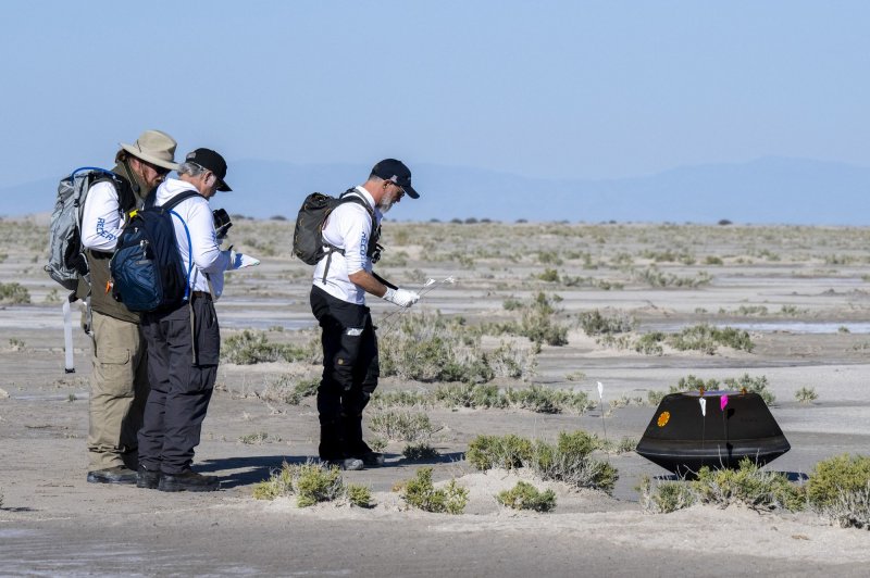 From left to right, NASA Astromaterials Curator Francis McCubbin, NASA Sample Return Capsule Science Lead Scott Sandford, and University of Arizona OSIRIS-REx Principal Investigator Dante Lauretta, collect science data, on Sunday, shortly after the sample return capsule from NASA's OSIRIS-REx mission landed at the Department of Defense's Utah Test and Training Range. NASA Photo by Keegan Barber/UPI