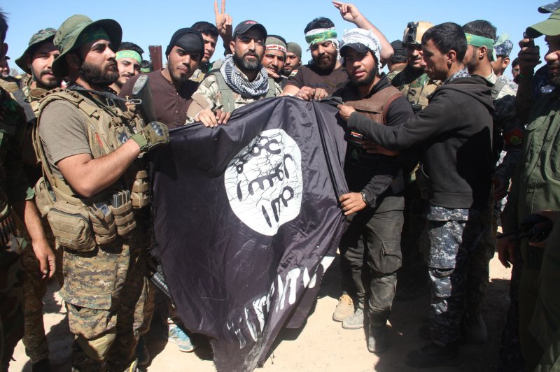 Iraqi soldiers show off a flag taken from Islamic State fighters near the city of Fallujah in June 2016, during an operation to regain control of the area from militants. File Photo by Karrar Hazem /UPI | <a href="/News_Photos/lp/59b476cc7d1202662ba9843e989f40df/" target="_blank">License Photo</a>