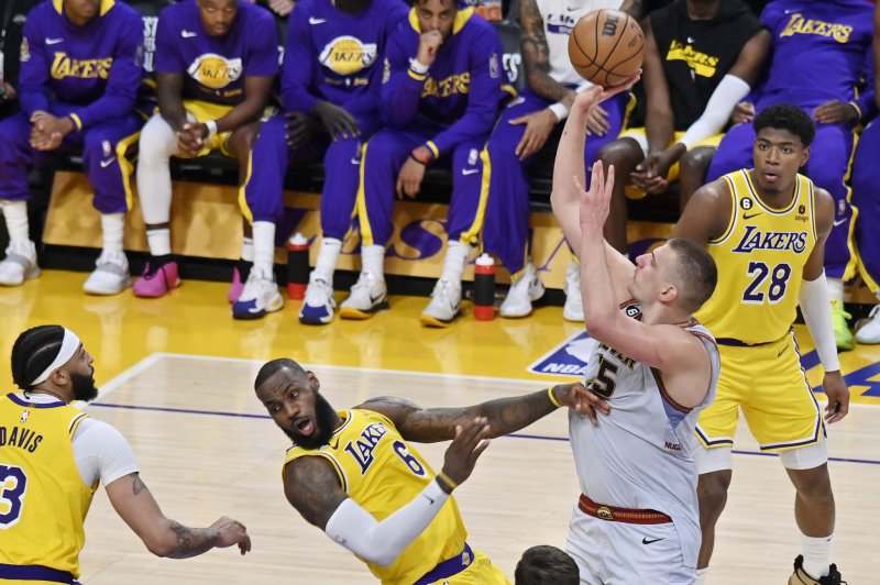 Los Angeles Lakers forward LeBron James (C) draws an offensive foul on Denver Nuggets center Nikola Jokic (R) during the fourth quarter of Game 4 of the Western Conference finals Monday at Crypto.com Arena in Los Angeles. Photo by Jim Ruymen/UPI