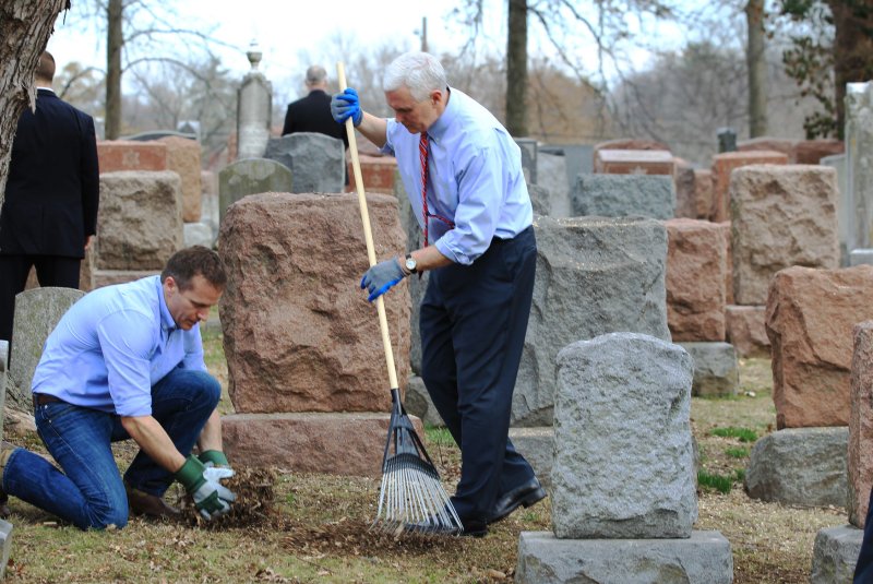 Vice President Mike Pence rakes leaves while Missouri Governor Eric Greitens (L) picks them up at Chesed Shel Emeth Cemetery in University City, Missouri on Wednesday. Vandals toppled nearly 200 headstones on February 20, 2017 in the Jewish cemetery. Pence, who was in town for another event, asked to go to the cemetery for the large community cleanup which attracted over four thousand people. Photo by Bill Greenblatt/UPI