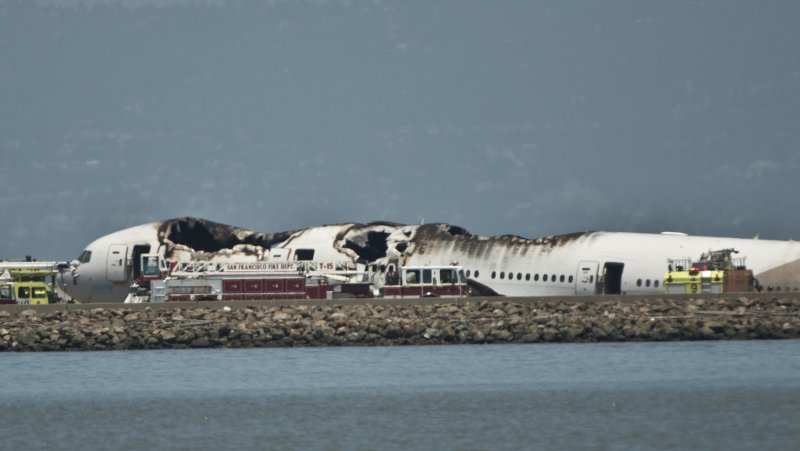 Emergency vehicles surround the remains of an Asiana Air Boeing 777 on the runway at San Francisco International Airport after it crashed on landing in San Francisco on July 6, 2013. The plane was arriving from Seoul. UPI/Terry Schmitt