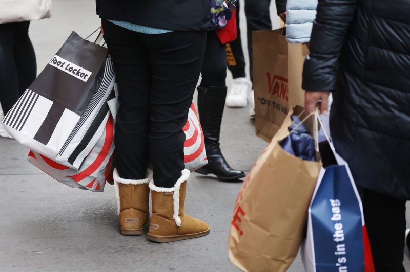People carry shopping bags as they walk in Herald Square on Black Friday in New York City on Friday. For over a decade, Black Friday has traditionally been the official start to the busy buying binge sandwiched between Thanksgiving and Christmas. Photo by John Angelillo/UPI