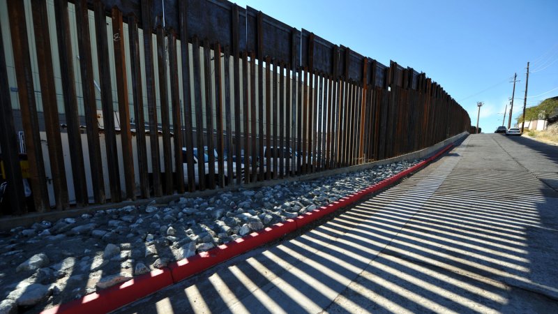 The border fence between the United States and Mexico creates a shadow pattern on a street in Nogalas, Arizona. UPI /Art Foxall