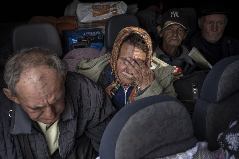 A woman wipes away tears while siting in a van after being evacuated from the recently liberated town of Ryska Lozova outside of Kharkiv, Ukraine Saturday. Photo by Ken Cedeno/UPI