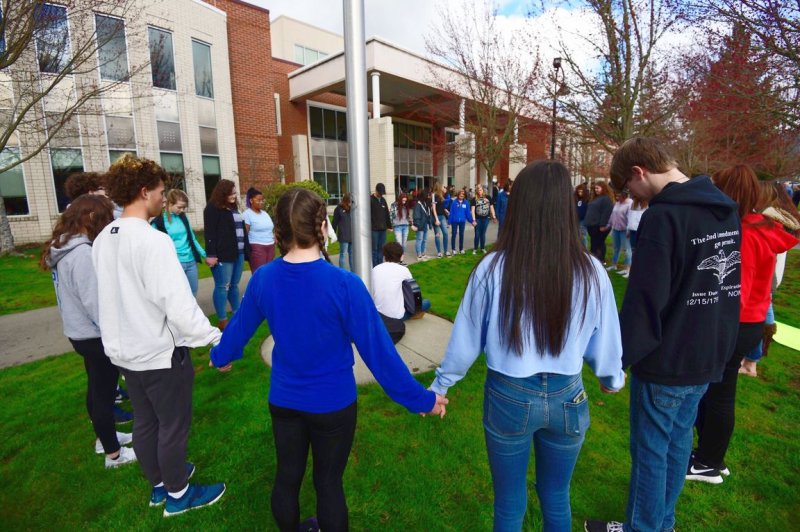 Grants Pass High School students participate in a prayer circle during a national walkout to honor Florida school shooting victims in Grants Pass, Ore., on March 14, 2018. On June 25, 1962, the U.S. Supreme Court handed down a decision interpreted as barring prayer in public schools. File Photo by David Tulis/UPI