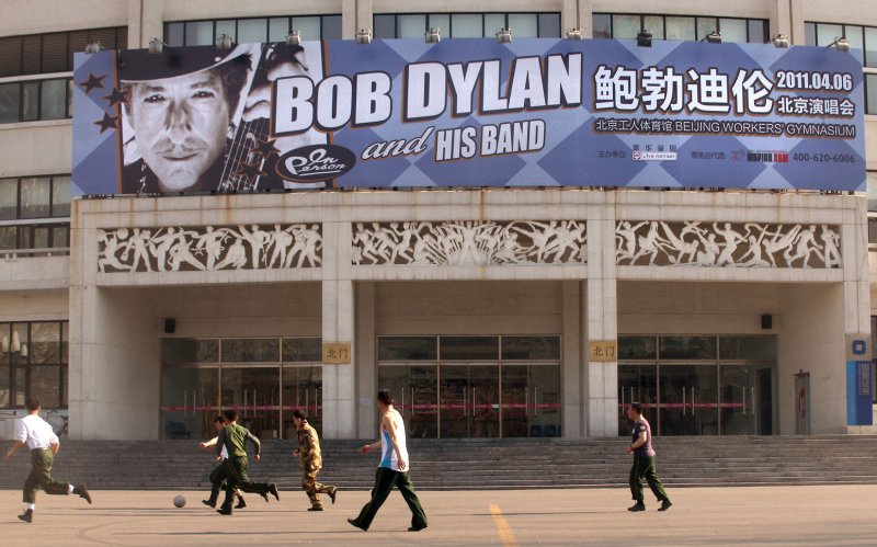 Chinese soldiers play soccer in front of Beijing's iconic Worker's Gymnasium, which will host Bob Dylan's first-ever concert in China tomorrow, on April 5, 2011. Last year Chinese authorities refused to allow the legendary protest singer Bob Dylan to play concerts inside China. Chinese censors were wary of his politically charged lyrics, which inspired a generation of Americans in the 1960s and '70s to question authority in a way that is forbidden in China. Officials said the singer would have to strictly abide by an agreed playlist. UPI/Stephen Shaver | <a href="/News_Photos/lp/4394f59771458d473b11c532e30a8036/" target="_blank">License Photo</a>